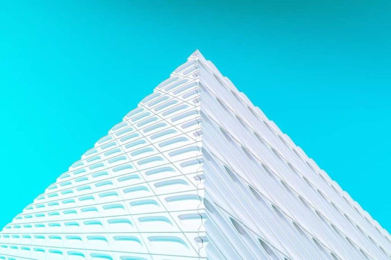 Hochmodernes, geometrisches Gebäude mit dynamischer Architektur gegen blauen Himmel.