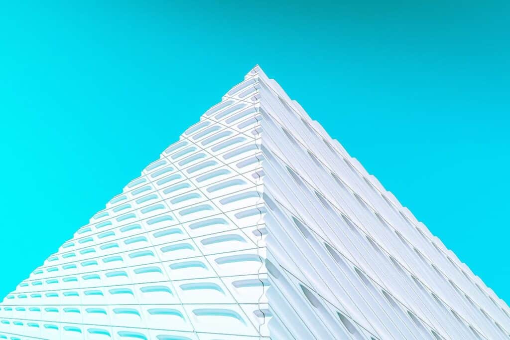 Hochmodernes, geometrisches Gebäude mit dynamischer Architektur gegen blauen Himmel.